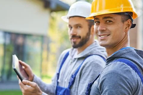 We will get it done. Portrait of two young male builders smiling at camera Stock Photos