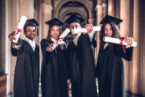 We worked hard and got results!Group of smiling graduates showing their diplo Stock Photos