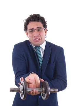 Weak man in suit lifting a weight Stock Photos