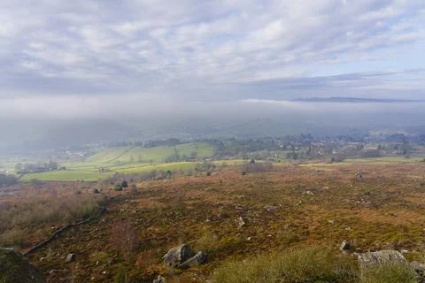 Weak winter sunlight cuts through dense fog in Hope Valley, Derbyshire. Stock Photos