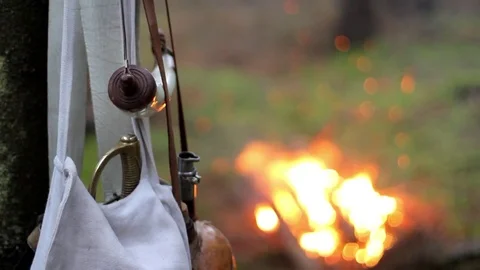 A weapon hanging from a tree, a sword and a horn, a light fire in the forest, a  Stock Footage 80593298