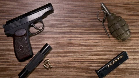 The weapon lies on the table: a cannon, a grenade, handcuffs, clips, bullets Video stock 74445533