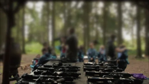 Weapons on the table, preparation for the game of war. Fake guns, paintball Stock Footage 219610499