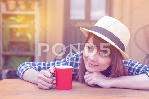 Wear hat woman sitting in outdoor with warm drink relax pastel color tone Stock Photos