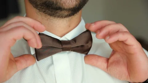 Wearing bow tie close up. Check correct and adjust casual brown bow tie Stock Footage 96985500