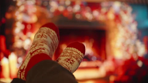 Wearing Red and White Patterned Socks Sitting with Feet Up by Fireplace in Cozy Stock Footage 340264511