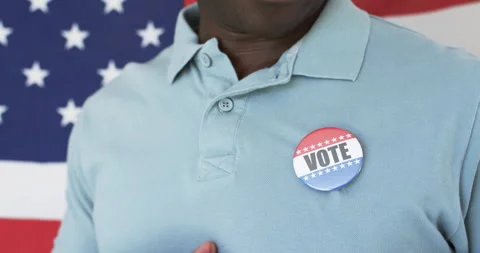 Wearing VOTE button, person standing in front of American flag animation Stock Footage 305077658