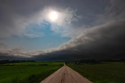 WEATHER - Dramatic black rain clouds over fields and country road. Foto stock
