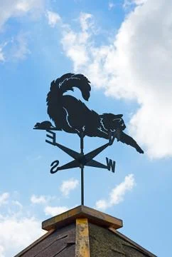 Weather vane on background of blue sky and clouds. Stock Photos