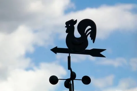 Weather vane on a backgrounds a cloudy sky Weather vane on a backgrounds a... 写真素材