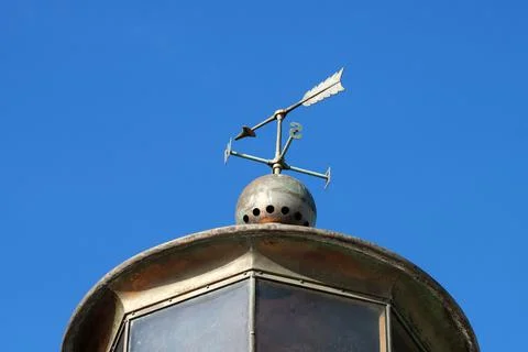 Weather vane on the lighthouse against the background of clear sky Stock Photos