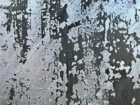 Weathered and distressed metallic surface with peeling black paint Stock Photos