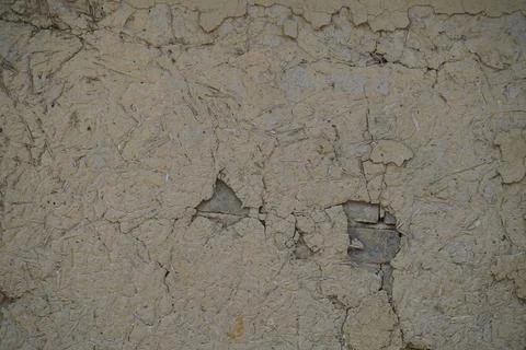 Weathered beige concrete wall texture with cracks and peeling plaster surface ba Stock Photos