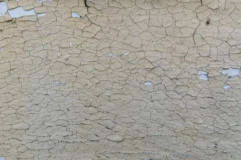 Weathered beige cracked wall texture with peeling paint surface Stock Photos
