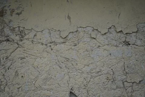 Weathered beige mud wall texture with cracked plaster and rough organic surface Stock Photos