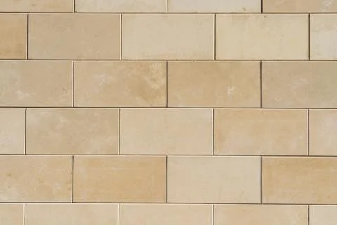 Weathered Beige Stone Block Wall Texture with Natural Surface Marks Stock Photos