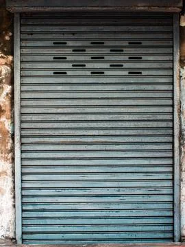Weathered Blue Metal Roller Shutter Door with Ventilation Slots, Rustic Sto.. Stock-Fotos