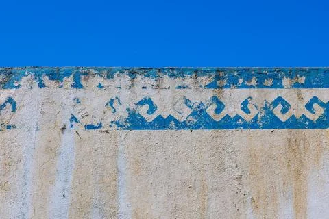 Weathered blue wall with geometric pattern outdoors in sunlight Stock Photos