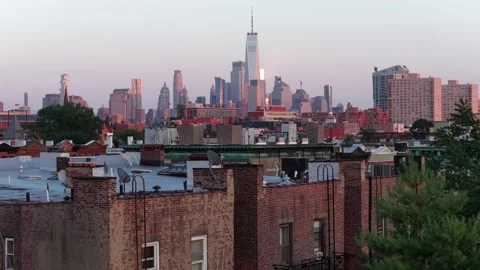 Weathered brick buildings with rusty fire escapes rise in foreground of Stock Footage 340969739