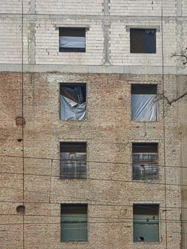 Weathered brick facade with covered windows Stock Photos