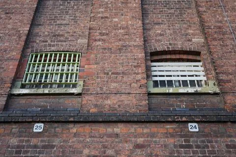 Weathered Brick Wall With Barred Windows 25 And 24, Shrewsbury Prison, England Stock Photos