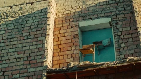 Weathered brick wall featuring a blue door and vintage chair Stock Footage 341128960