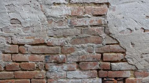 Weathered Brick Wall With Peeling Plaster in Urban Setting Stock Photos