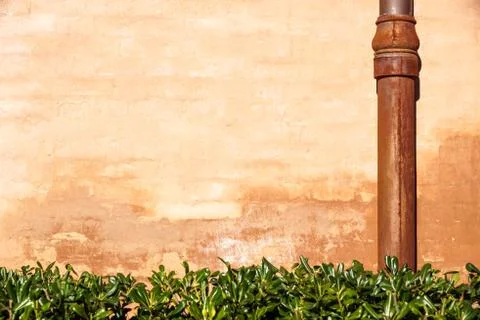 Weathered brick wall with pipe gutter. Detail of the facade of a house Stock Photos