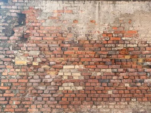 Weathered brick wall with plaster remnants grunge texture Stock Photos