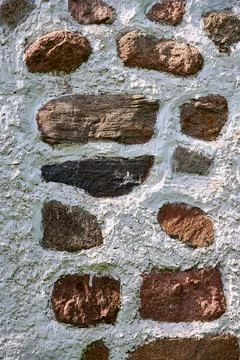 Weathered brick wall showing rough stone texture under soft light Stock Photos