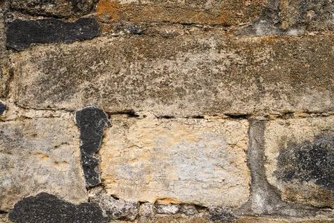 A weathered brown brick pattern volcanic stone wall with rough textured mas.. Stock Photos