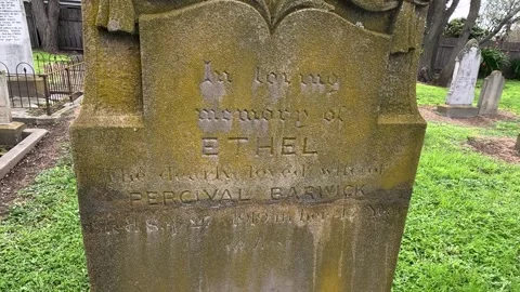 Weathered Cemetery Headstone Close Up with Old Graves Behind Stock Footage 338019964