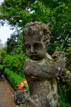 A weathered cherub statue in one of many gardens of Charleston Foto stock
