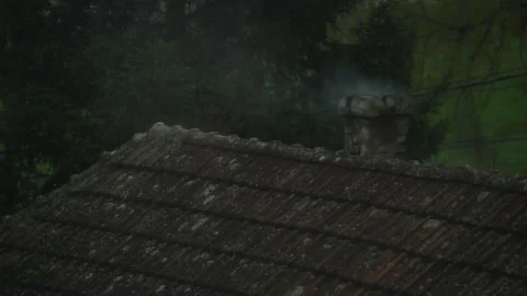 Weathered chimney stack releasing thick smoke from an old house roof, class.. Stock Footage 325864847