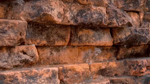 Weathered, coarse texture of ancient reddish-orange brick or laterite stone wall Stock Footage 340459611
