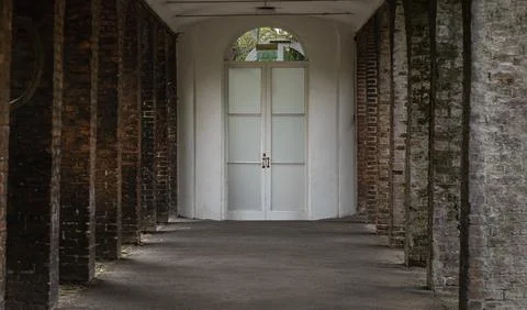 A weathered colonnade creates a rigorous, rhythmic perspective through stou.. Stock Photos