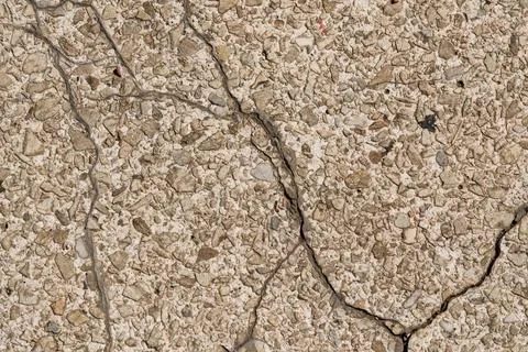 Weathered Concrete Pavement Texture with Network of Deep Cracks and Pebbles. Stock Photos