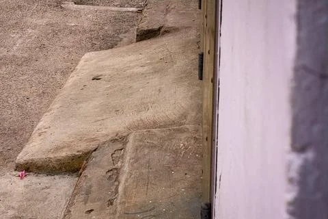 Weathered concrete step with textured surface near a wall Stock Photos