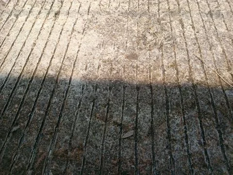 Weathered concrete surface with parallel grooves and rough texture, partly .. Stock Photos