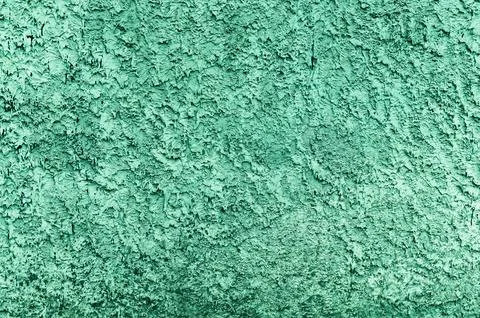 Weathered concrete wall demonstrates rough green plaster texture with relief Foto stock