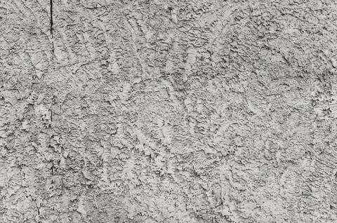 Weathered concrete wall demonstrates rough plaster texture with embossed Stock Photos