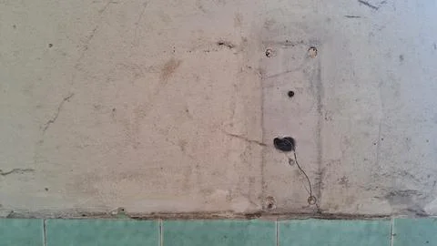 Weathered concrete wall surface featuring exposed electrical wiring details Stock Photos