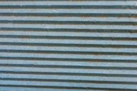Weathered corrugated metal sheet with linear texture and orange oxidation Stock Photos