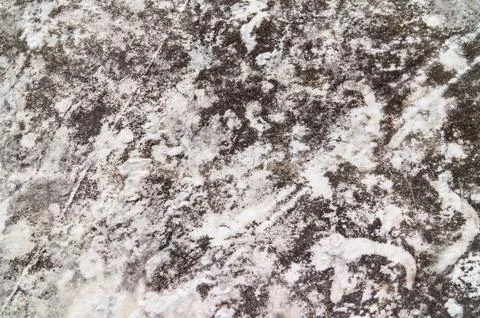Weathered dark stone surface with white mineral veins and mottled texture Stock Photos