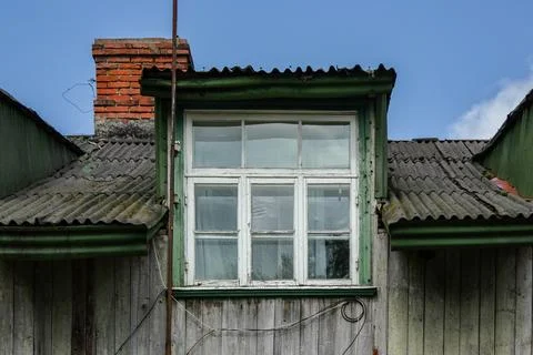 Weathered Dormer Window on an Old House Roof with Chimney Foto stock