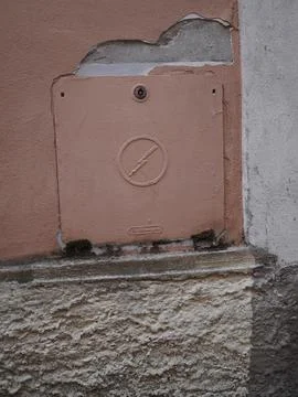 Weathered electrical panel with chipped pink paint, lightning bolt symbol, Stock Photos