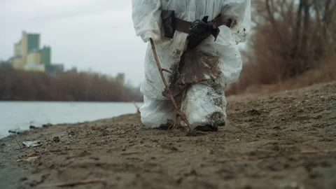 Weathered explorer advances through muddy coast line. Persistence shown by lone Stock Footage 346462847