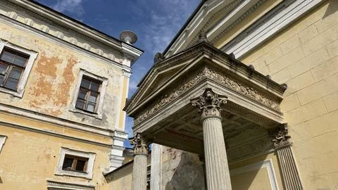 Weathered facade of an old classical yellow mansion featuring a decorative Foto stock