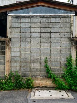 Weathered Gray Cinder Block Garage Wall with Wooden Roof Beam 库存照片