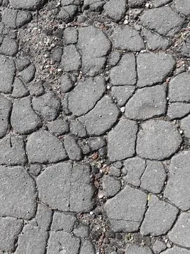 Weathered Gray Cracked Asphalt Surface Background. Stock Photos